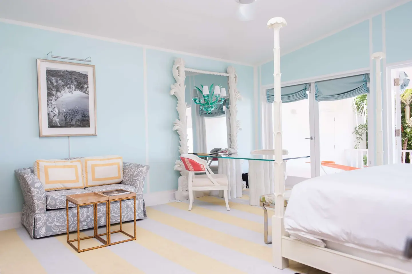 Pastel guest room with four-poster bed and seating at Malliouhana Resort Anguilla.
