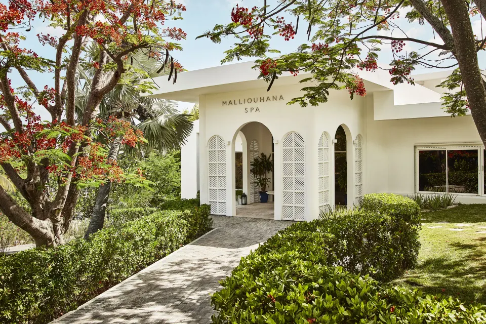 White spa entrance with arched doorway and gardens at Malliouhana Resort Anguilla.