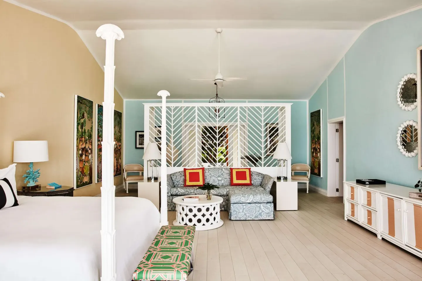 Spacious guest room with bed, sofa, and colorful walls at Malliouhana Resort Anguilla.
