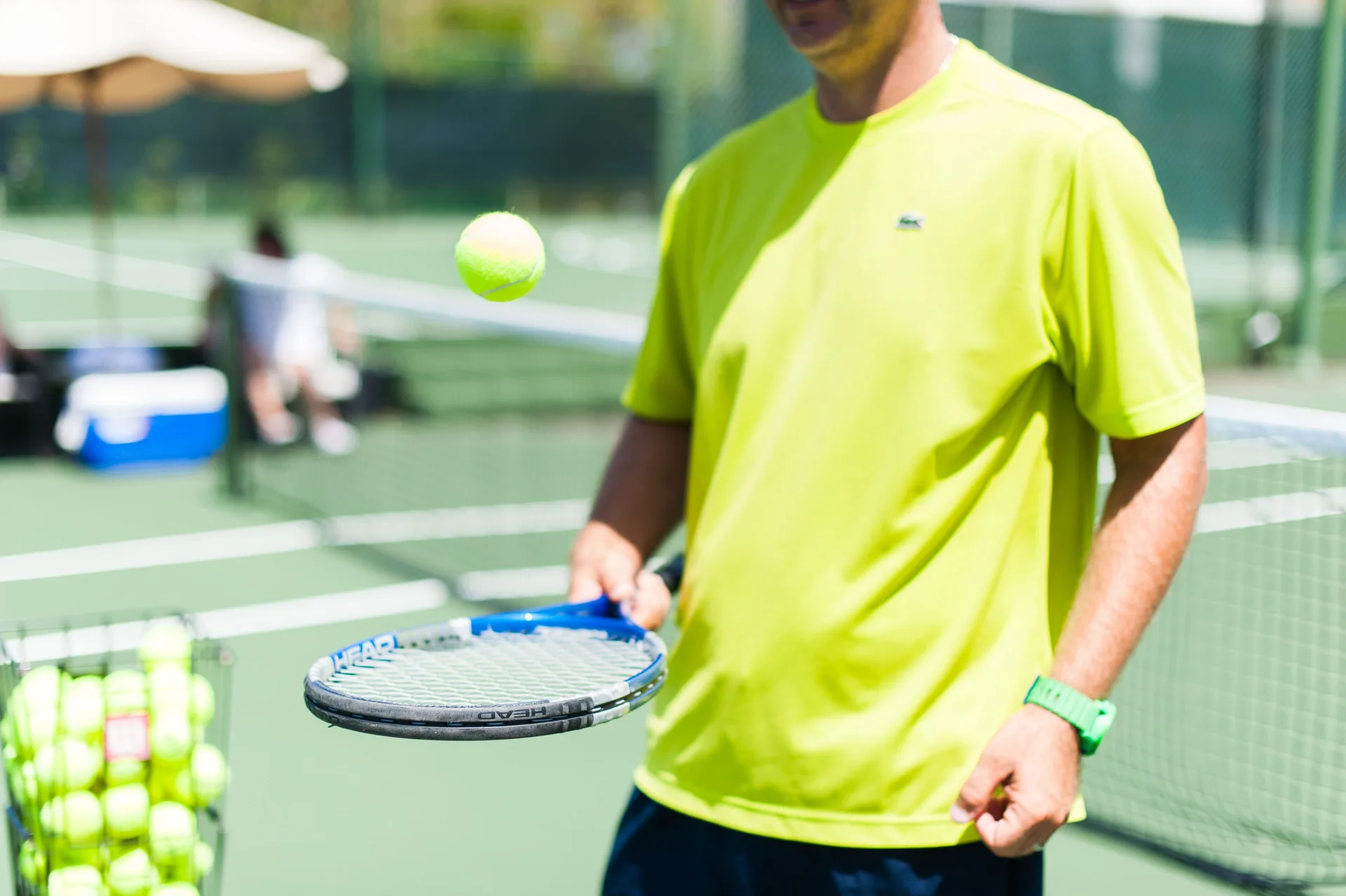 A tennis player balances a ball on a racket at Malliouhana Resort Anguilla.