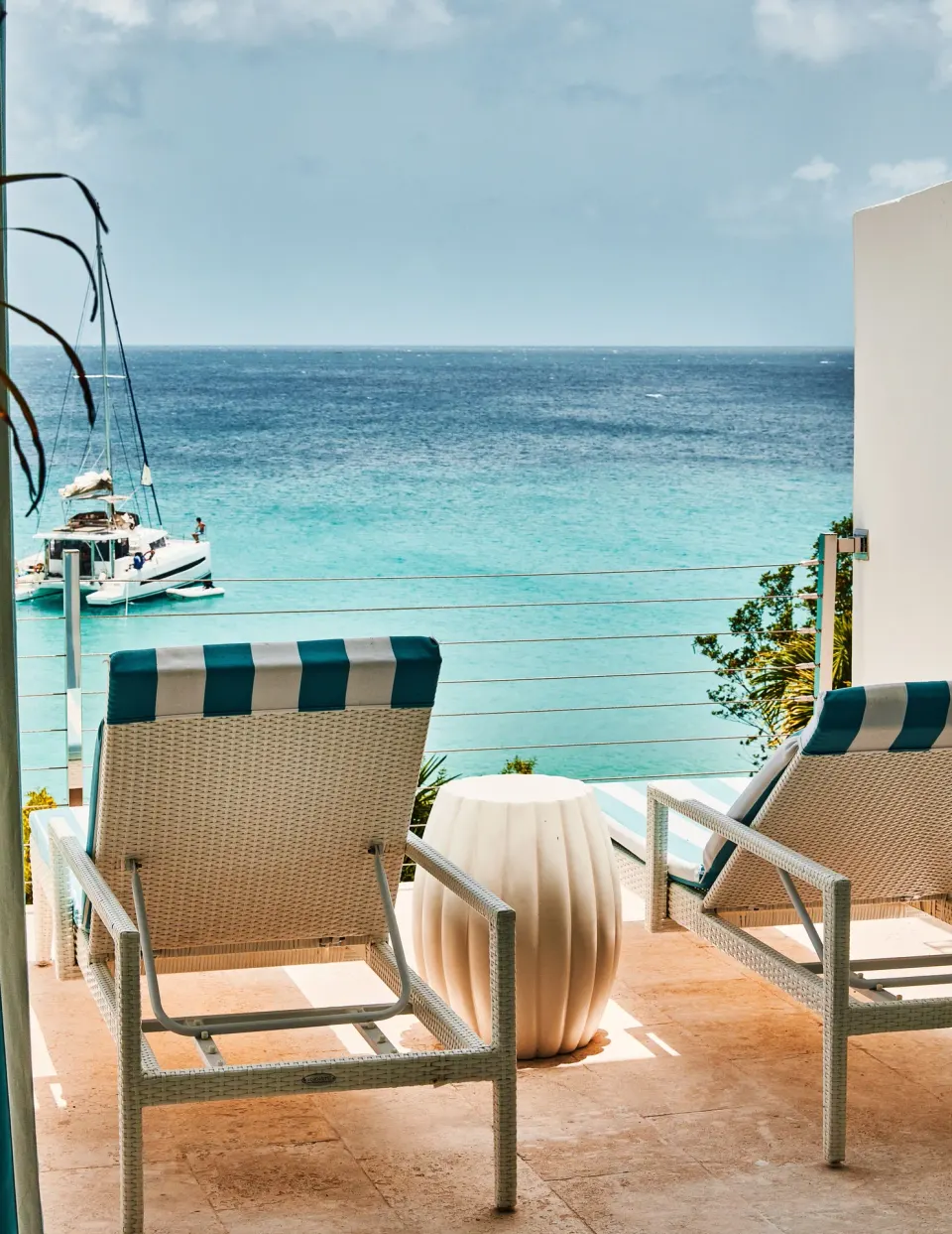Terrace lounge chairs overlooking turquoise sea at Malliouhana Resort Anguilla.
