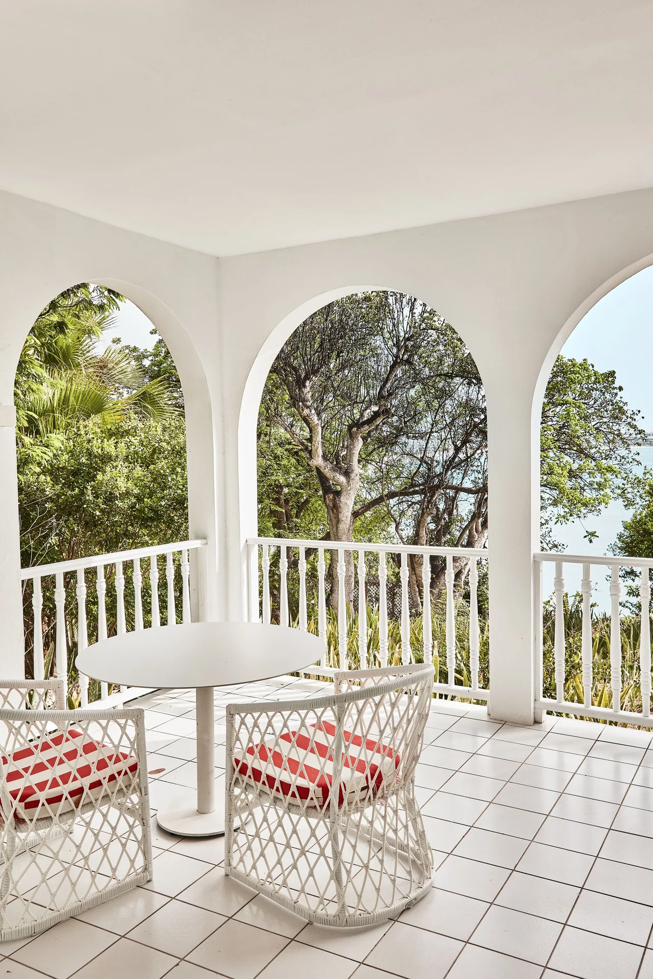 Garden View Deluxe balcony seating framed by arches at Malliouhana Resort Anguilla.