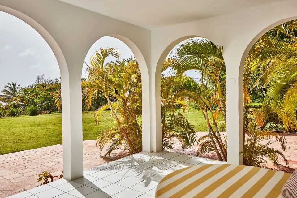 Garden View Deluxe terrace with arched openings and palms at Malliouhana Resort Anguilla.