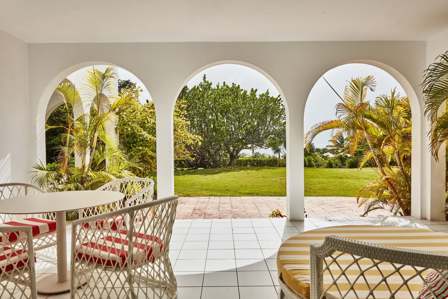 Garden View Deluxe covered patio with dining set and daybed at Malliouhana Resort Anguilla.