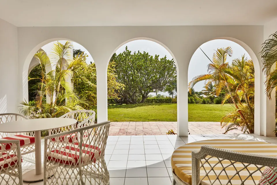 Garden View Deluxe covered patio with dining set and daybed at Malliouhana Resort Anguilla.