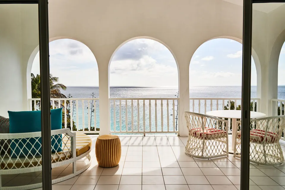 Ocean View Deluxe balcony with seating and ocean view at Malliouhana Resort Anguilla.