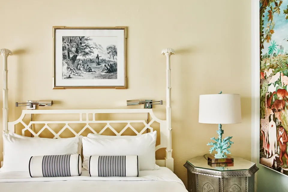 Close-up of an Ocean View Premium Two Beds bed at Malliouhana Resort Anguilla with lamp and tropical wall art.