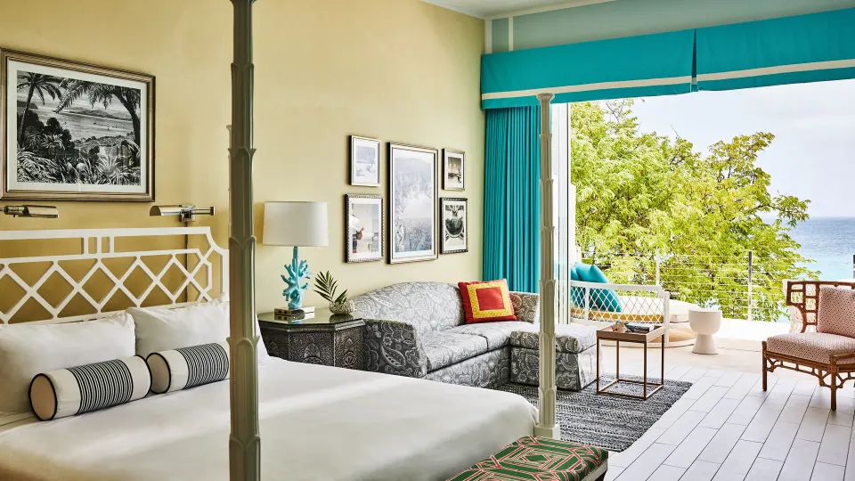 Spa Suite king bed and sitting area with ocean-facing terrace at Malliouhana Resort Anguilla.