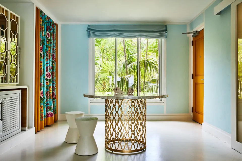 Turtle Cove Suite entry with round table and garden window at Malliouhana Resort Anguilla.