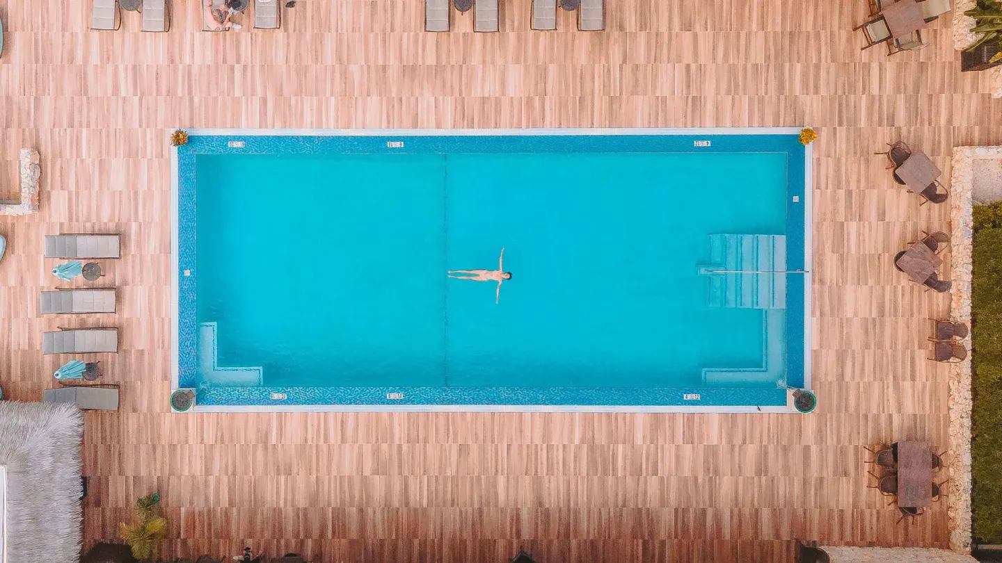 Aerial view of a swimmer floating in the pool at Manchebo Beach Resort and Spa.
