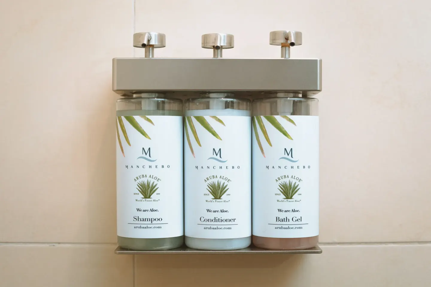 Wall-mounted shampoo, conditioner, and bath gel dispensers at Manchebo Beach Resort and Spa.