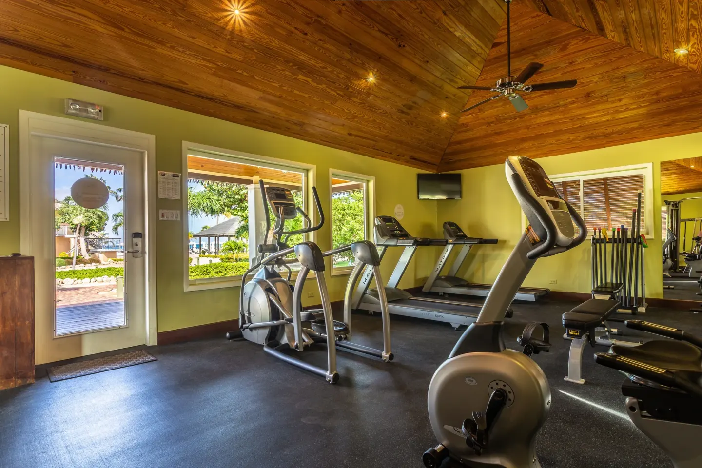Fitness room with cardio machines and weights at Manchebo Beach Resort and Spa.