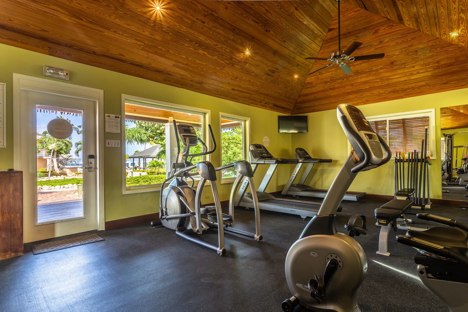 Fitness room with cardio machines and weights at Manchebo Beach Resort and Spa.