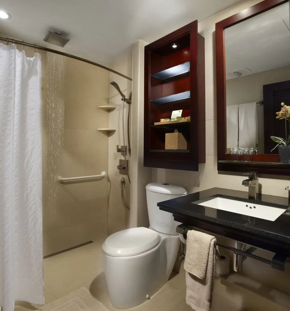 Guest bathroom with shower, toilet, and vanity at Manchebo Beach Resort and Spa.