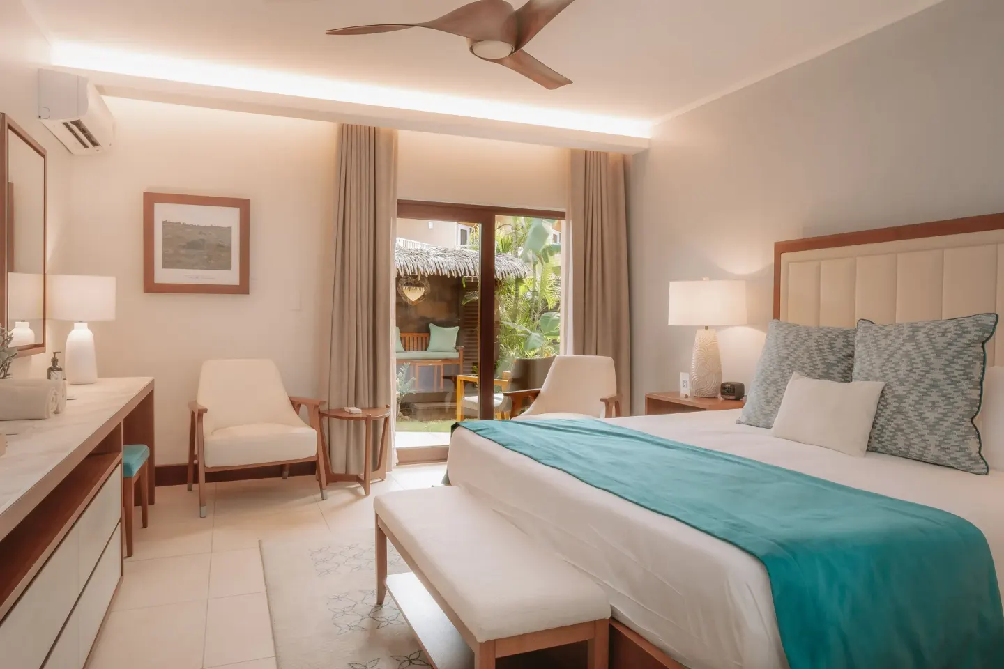 Guest room with a king bed and sliding doors to a patio at Manchebo Beach Resort and Spa.