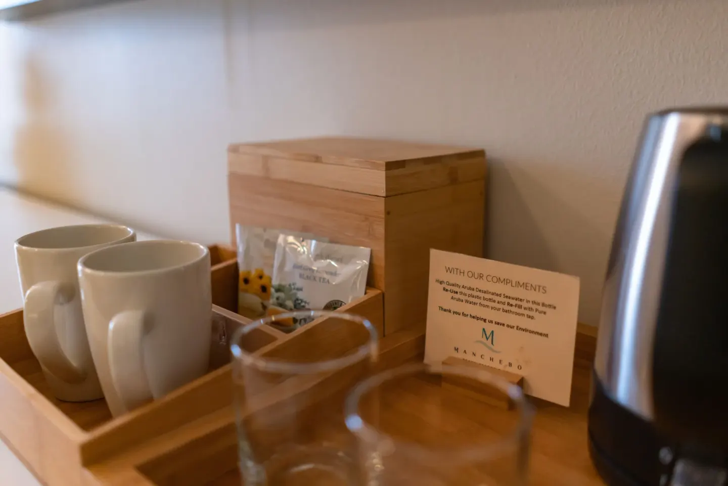 In-room coffee tray with mugs, glasses, tea and kettle at Manchebo Beach Resort and Spa.
