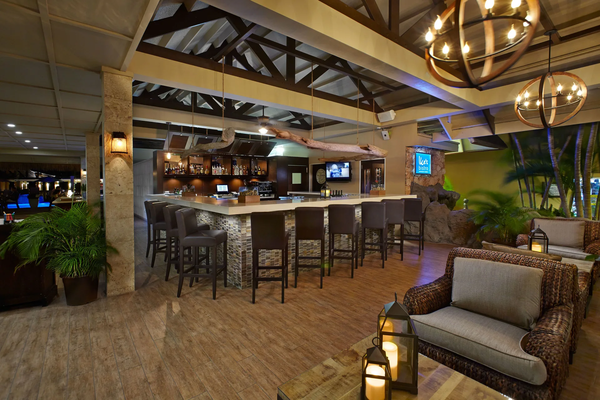 Open-air bar lounge with wicker seating at Manchebo Beach Resort and Spa.