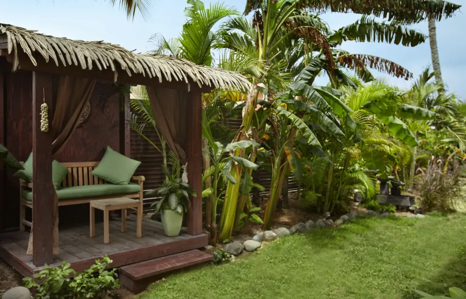Deluxe Garden View Room patio cabana and tropical garden at Manchebo Beach Resort and Spa.