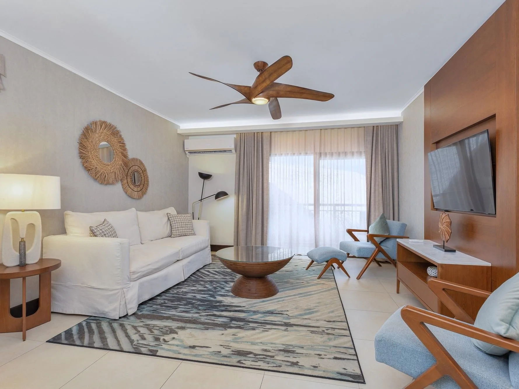 Deluxe Garden View room sitting area with sofa and TV at Manchebo Beach Resort and Spa.