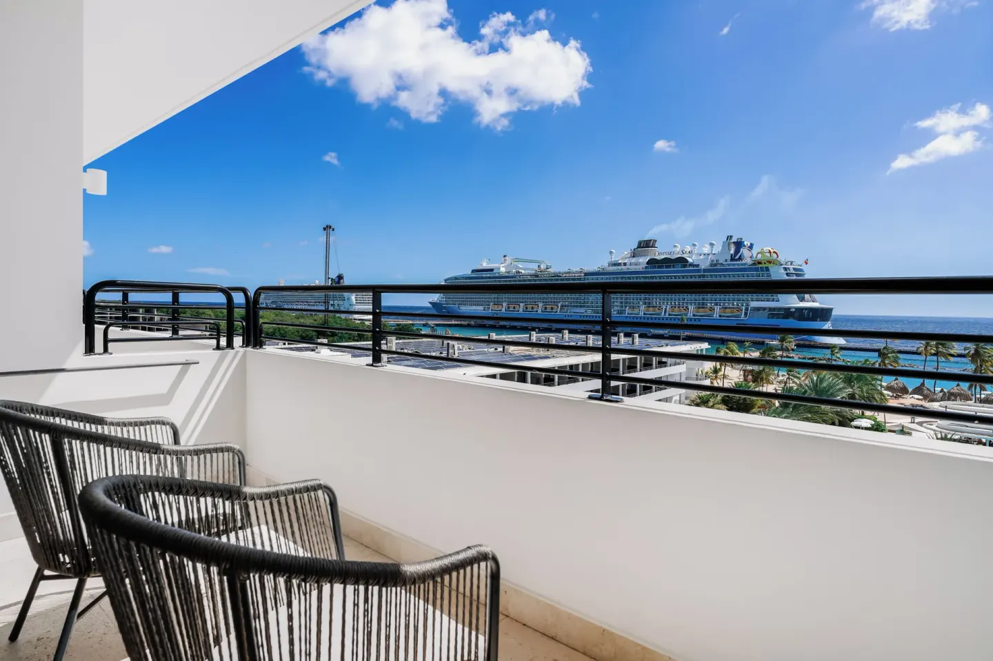 Balcony chairs overlooking the sea and harbor at Mangrove Beach Corendon Curacao Resort.