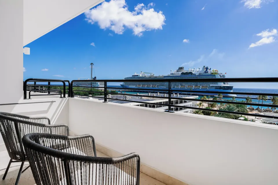 Balcony chairs overlooking the sea and harbor at Mangrove Beach Corendon Curacao Resort.