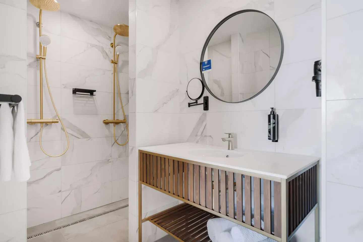 Bathroom sink and gold-tone shower fixtures at Mangrove Beach Corendon Curacao Resort.