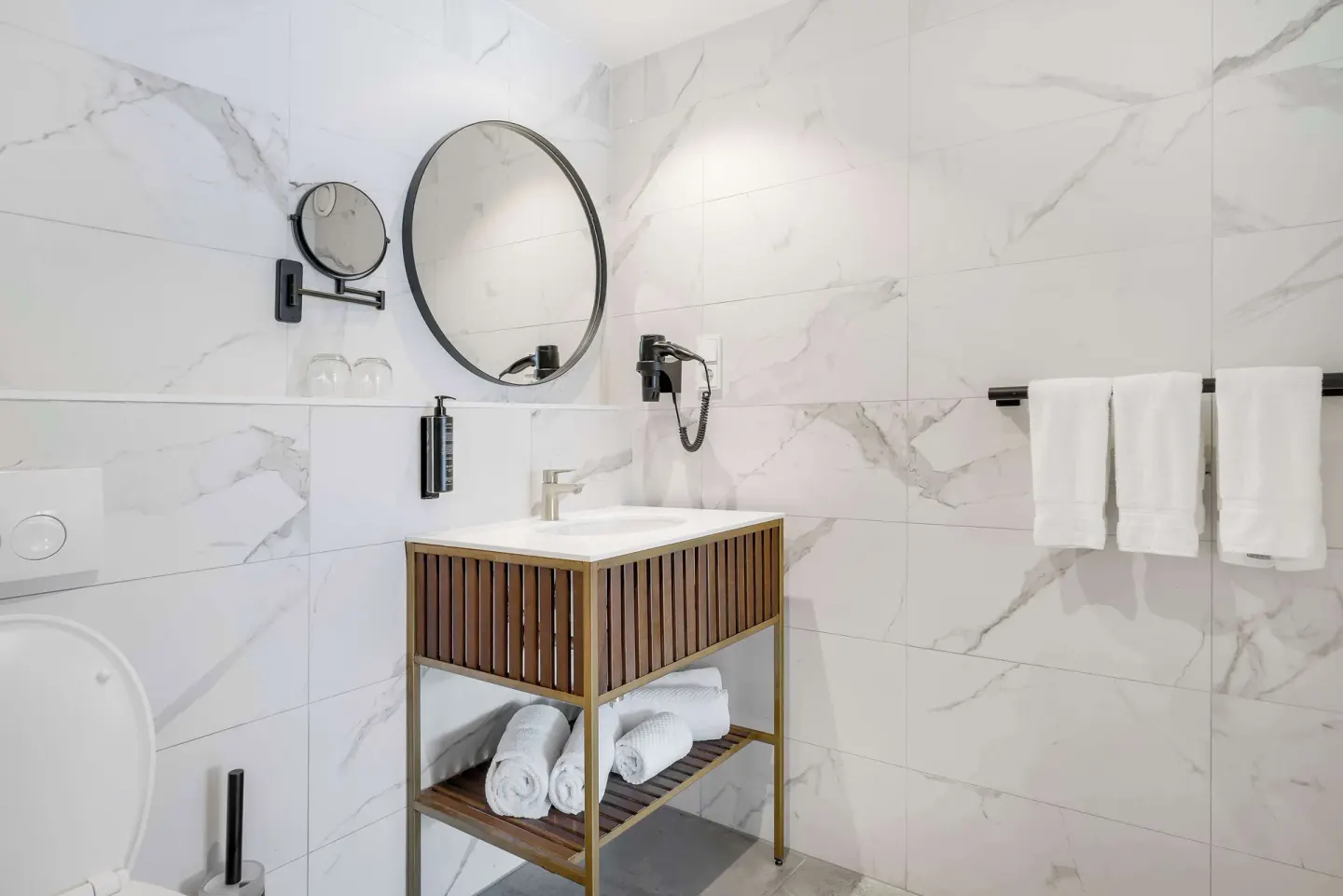 Bathroom vanity at Mangrove Beach Corendon Curacao Resort with towels, mirrors, and wall-mounted dryer.