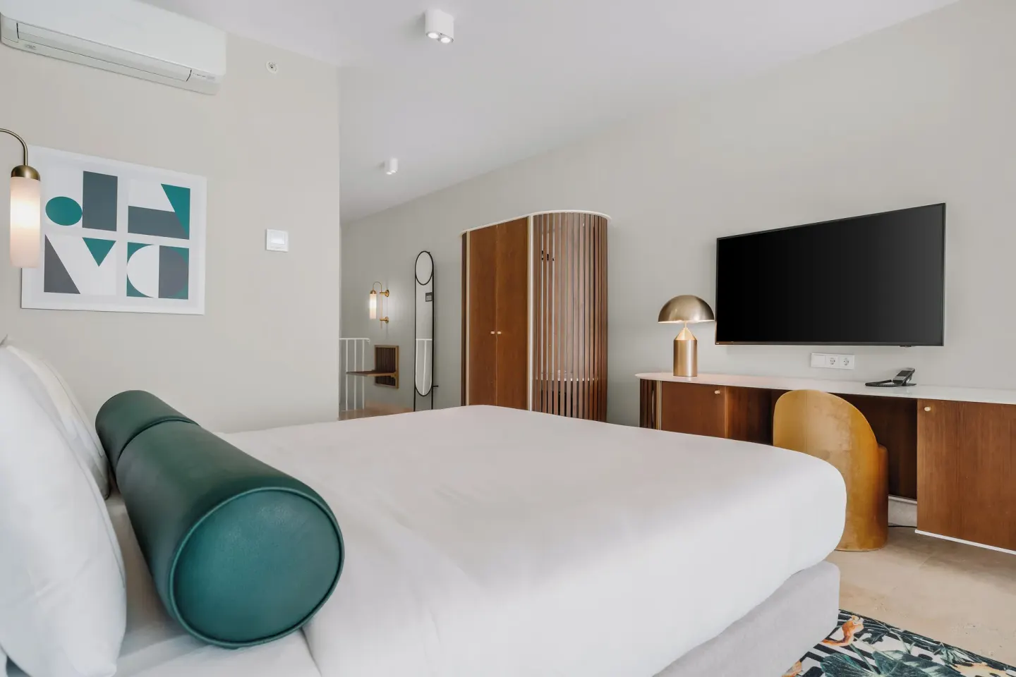 King bed guest room with abstract wall art and TV at Mangrove Beach Corendon Curacao Resort.