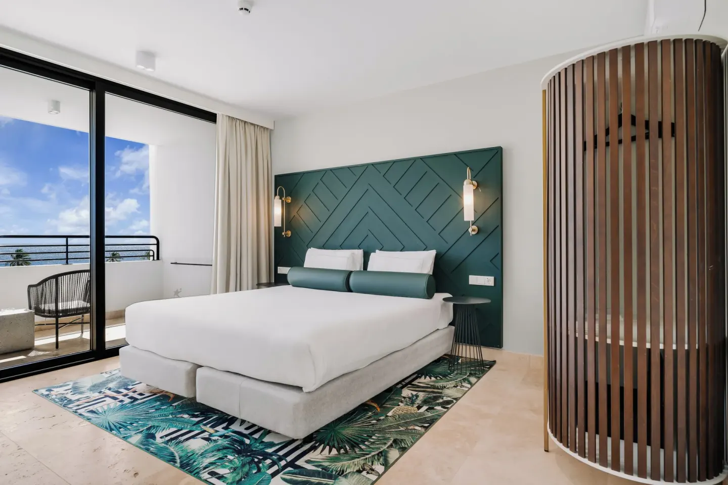 King bed guest room with balcony doors at Mangrove Beach Corendon Curacao Resort.