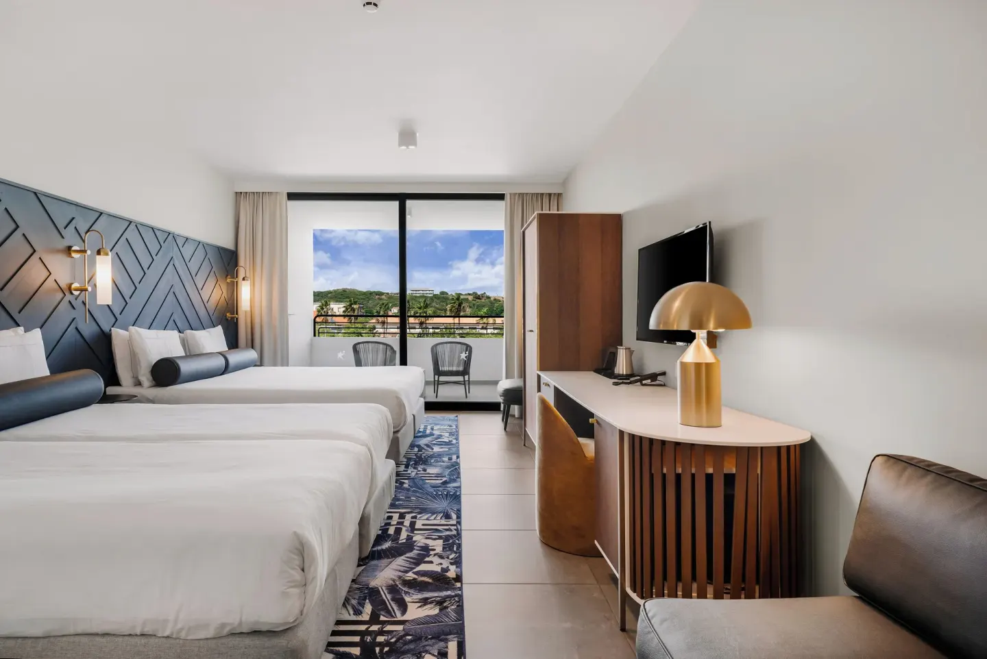 Two-bed guest room with balcony seating at Mangrove Beach Corendon Curacao Resort.