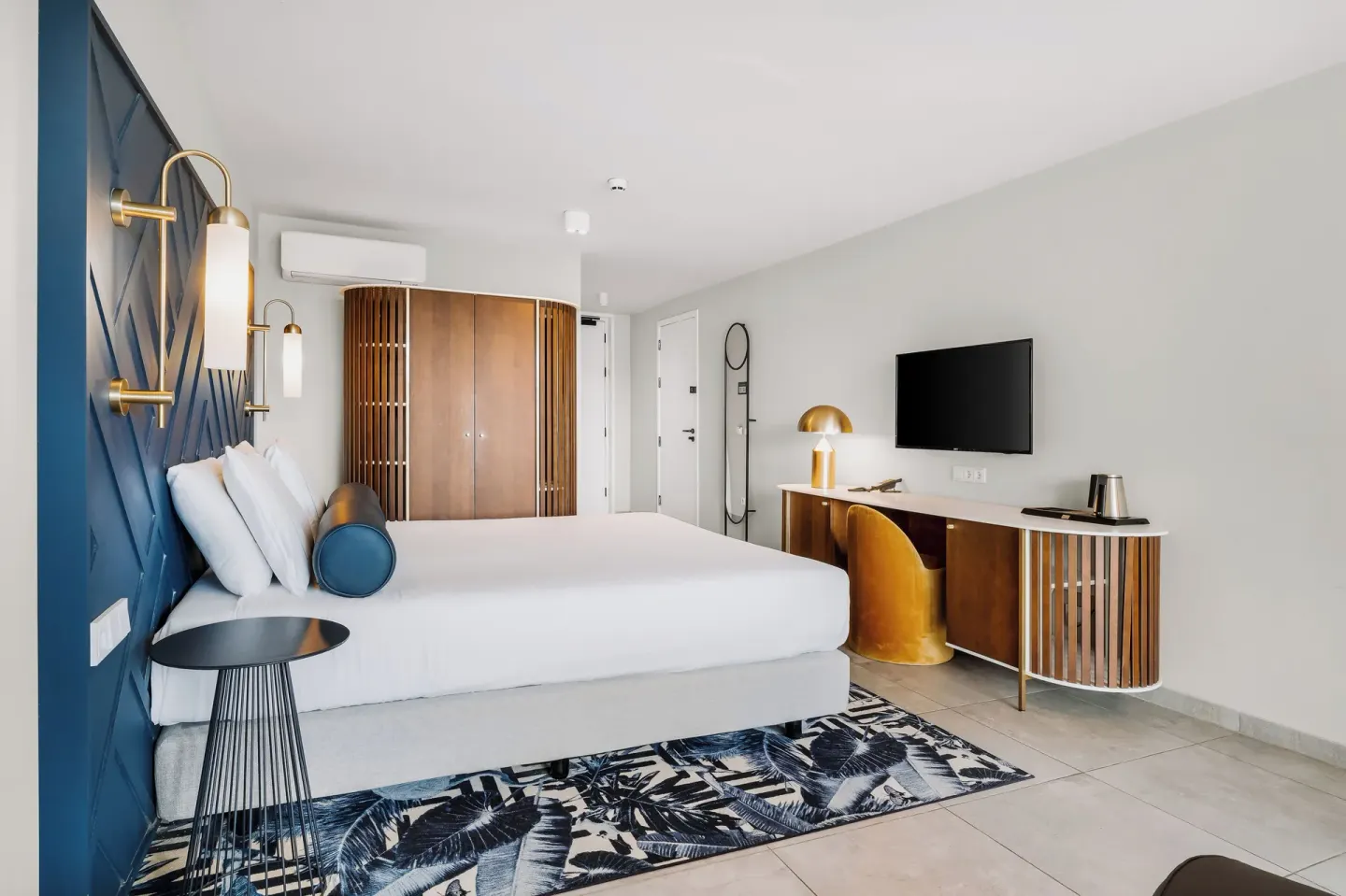 King bed guest room with desk and wall-mounted TV at Mangrove Beach Corendon Curacao Resort.