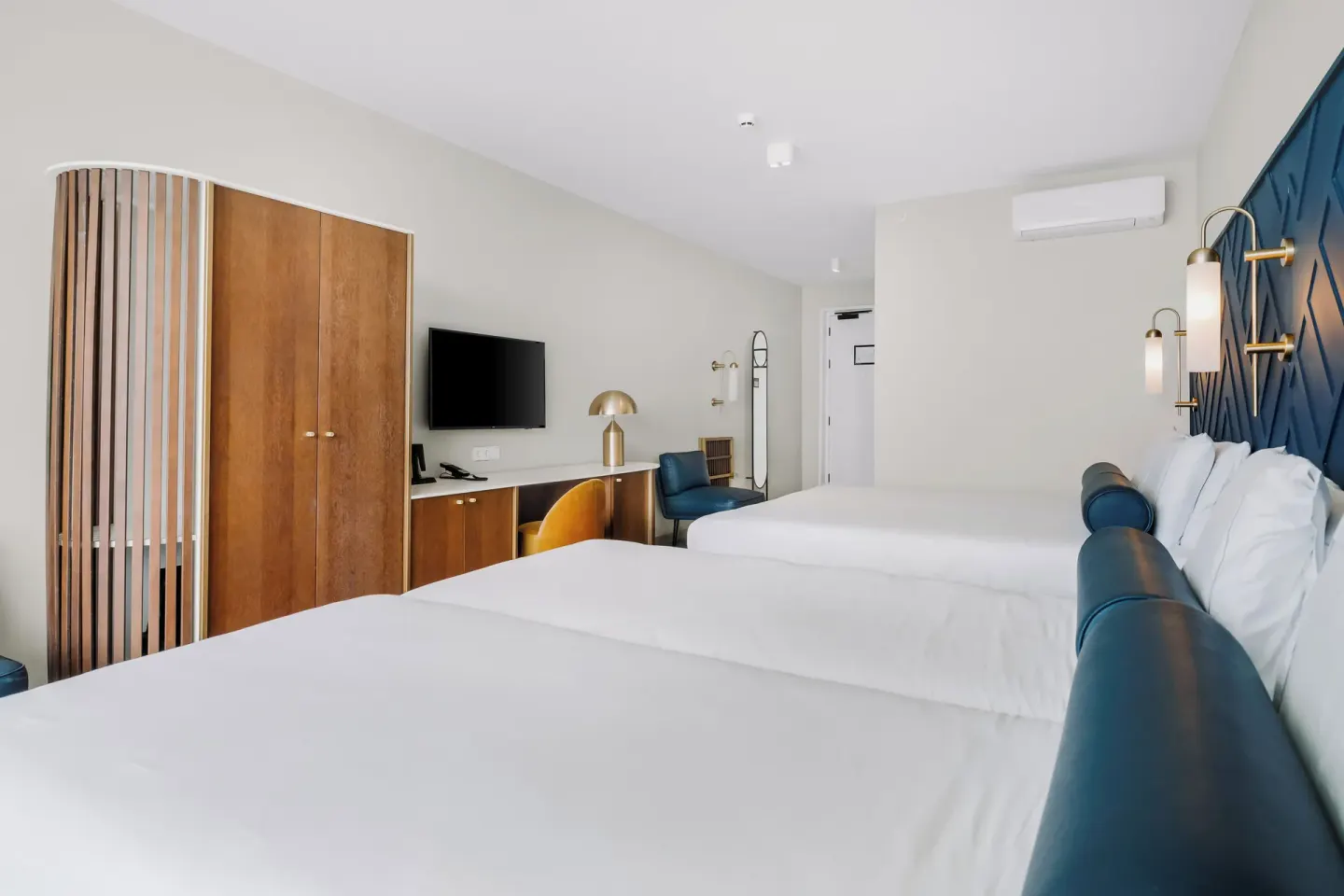 Two-bed guest room with desk and wardrobe at Mangrove Beach Corendon Curacao Resort.
