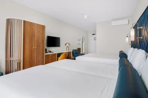 Two-bed guest room with desk and wardrobe at Mangrove Beach Corendon Curacao Resort.