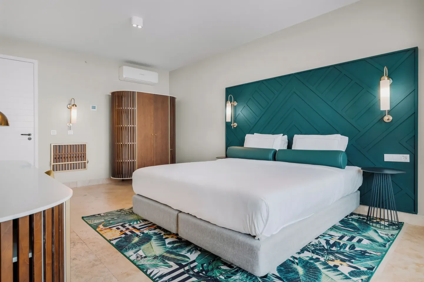 King bed with teal headboard in a guest room at Mangrove Beach Corendon Curacao Resort.
