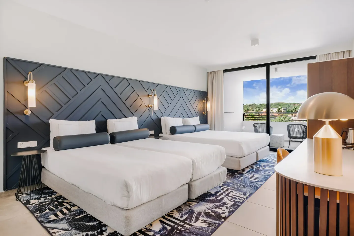 Two-bed guest room with patterned headboard at Mangrove Beach Corendon Curacao Resort.