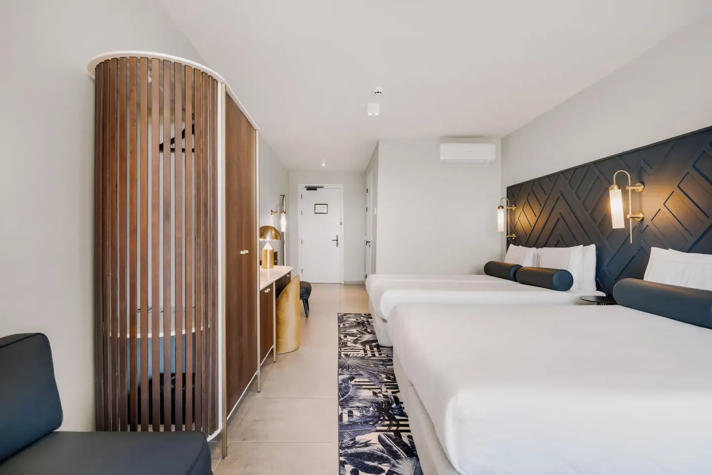 Two-bed guest room with wardrobe and entry view at Mangrove Beach Corendon Curacao Resort.