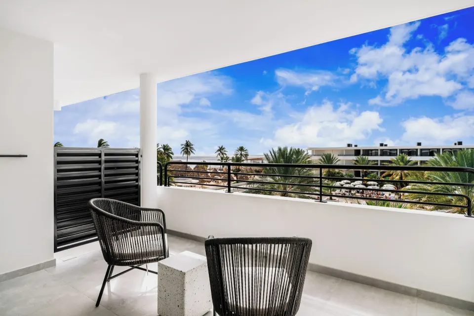 Balcony seating overlooking resort grounds at Mangrove Beach Corendon Curacao Resort.