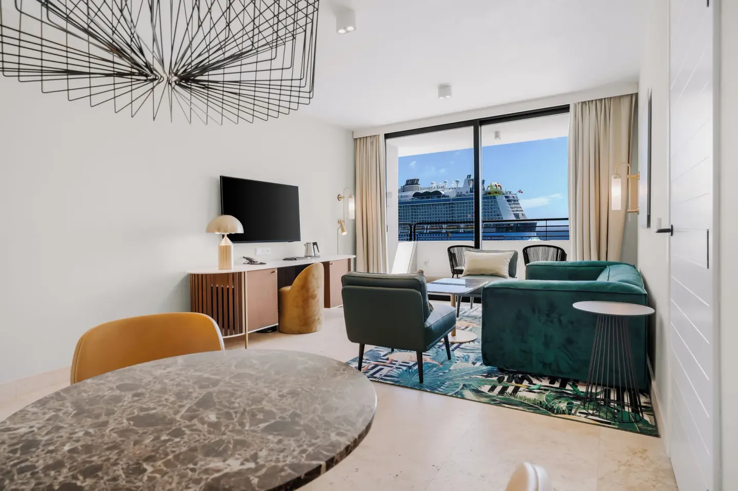 Suite lounge with balcony view and dining table at Mangrove Beach Corendon Curacao Resort.