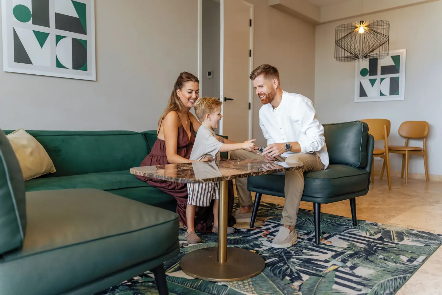 Family seated in a suite living area at Mangrove Beach Corendon Curacao Resort.