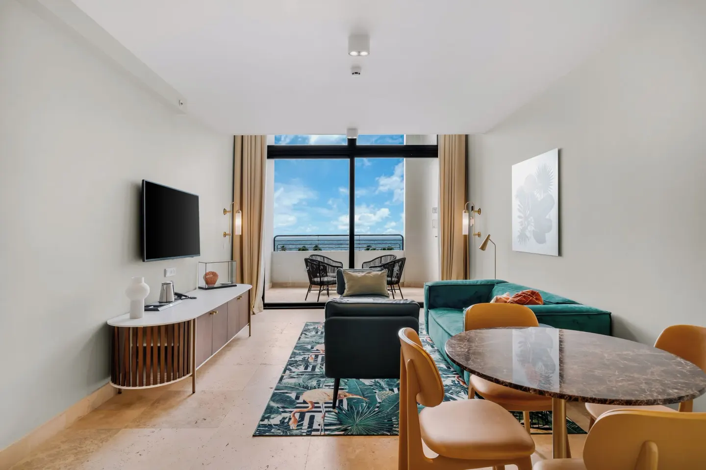 Suite lounge and dining area facing a balcony at Mangrove Beach Corendon Curacao Resort.