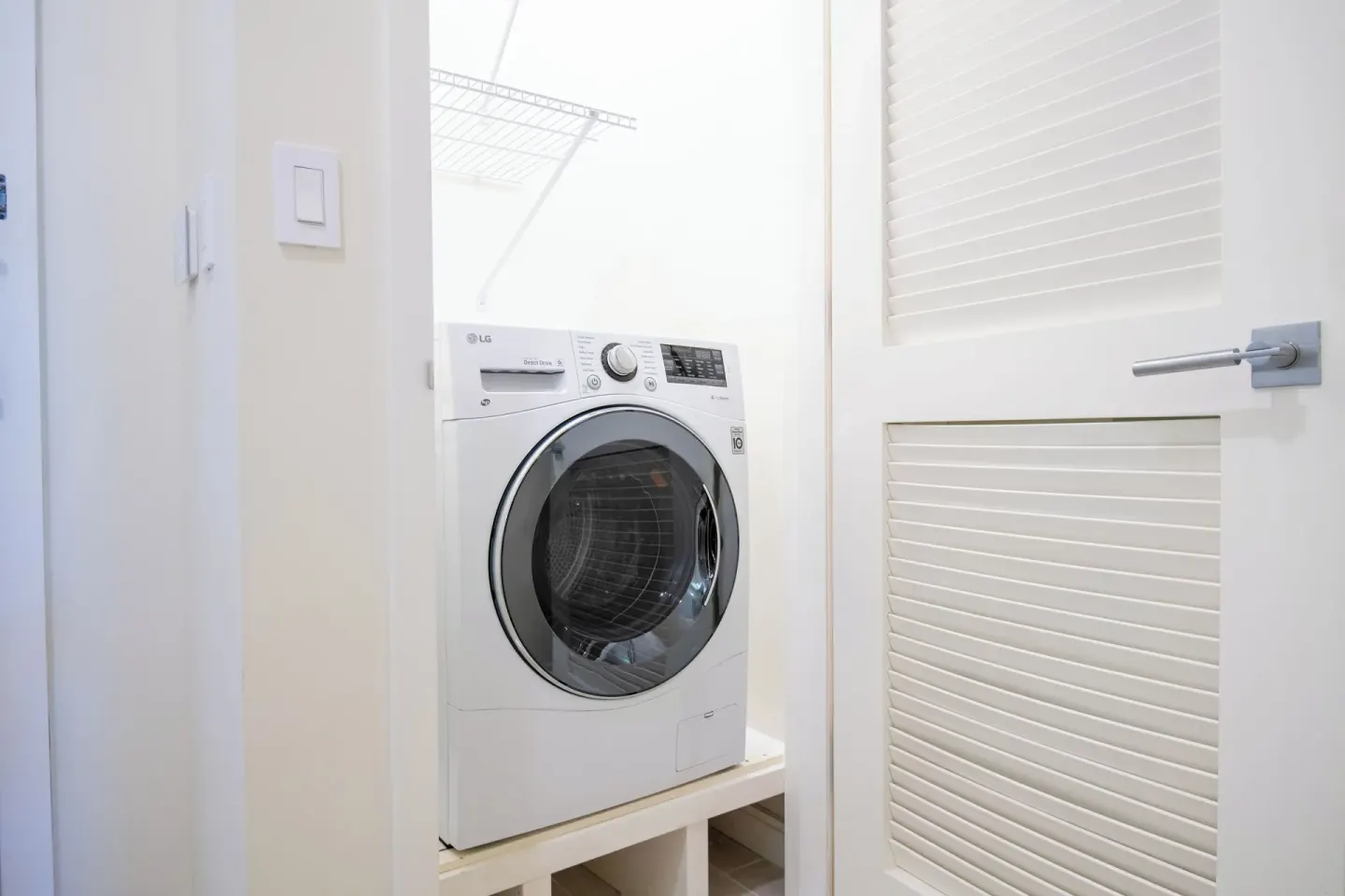 In-room laundry closet with front-loading appliance at Margaritaville Beach Resort - Nassau.