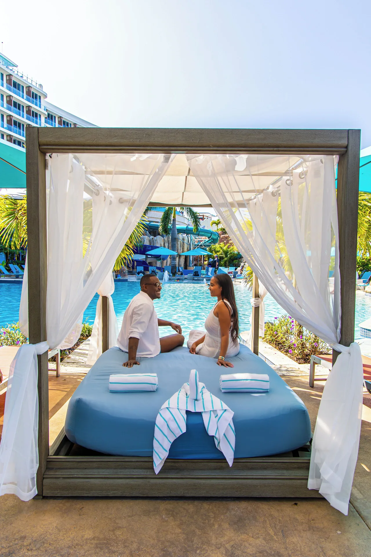 Poolside cabana daybed with guests at Margaritaville Beach Resort - Nassau.