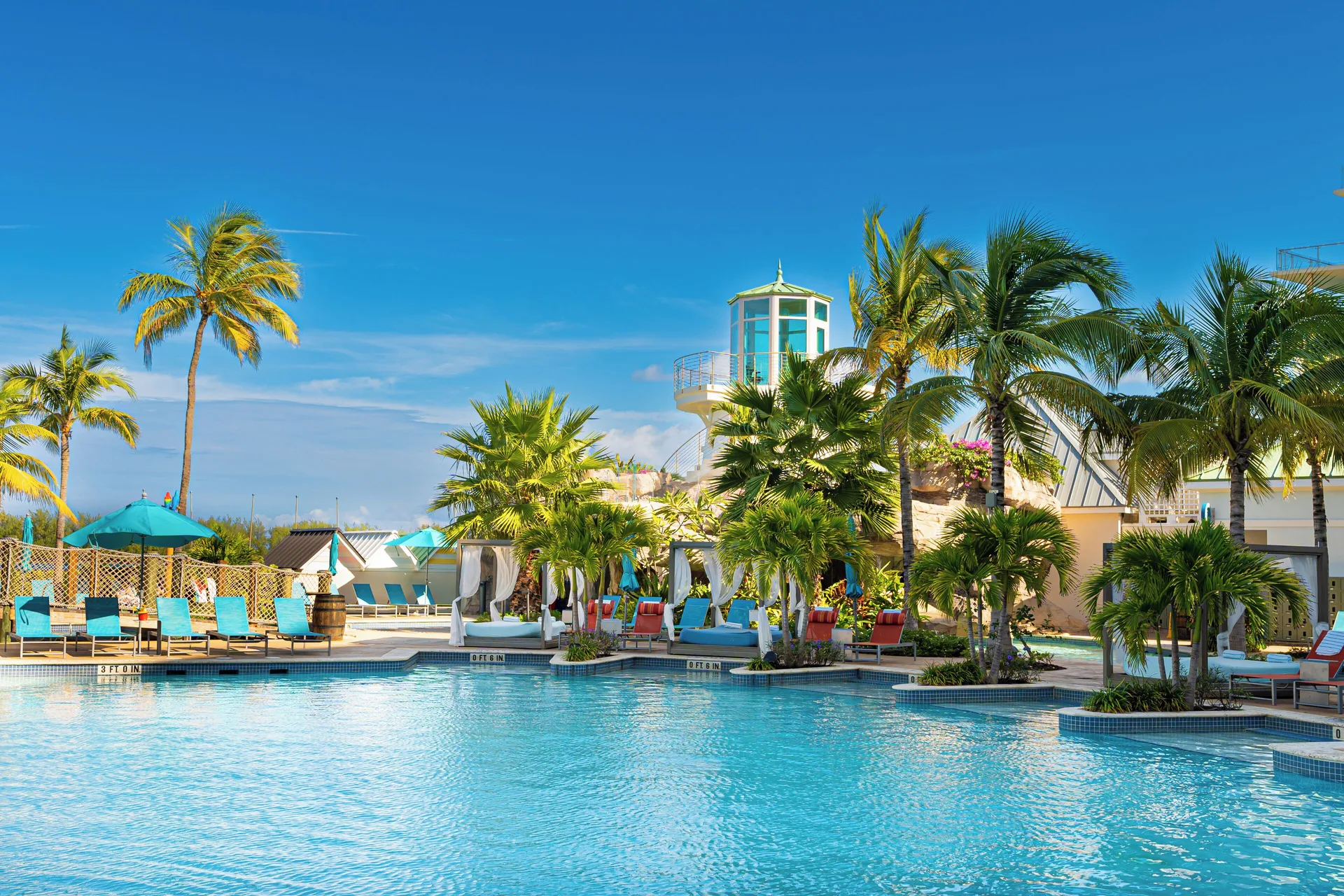 Resort pool with palm trees and cabanas at Margaritaville Beach Resort - Nassau.