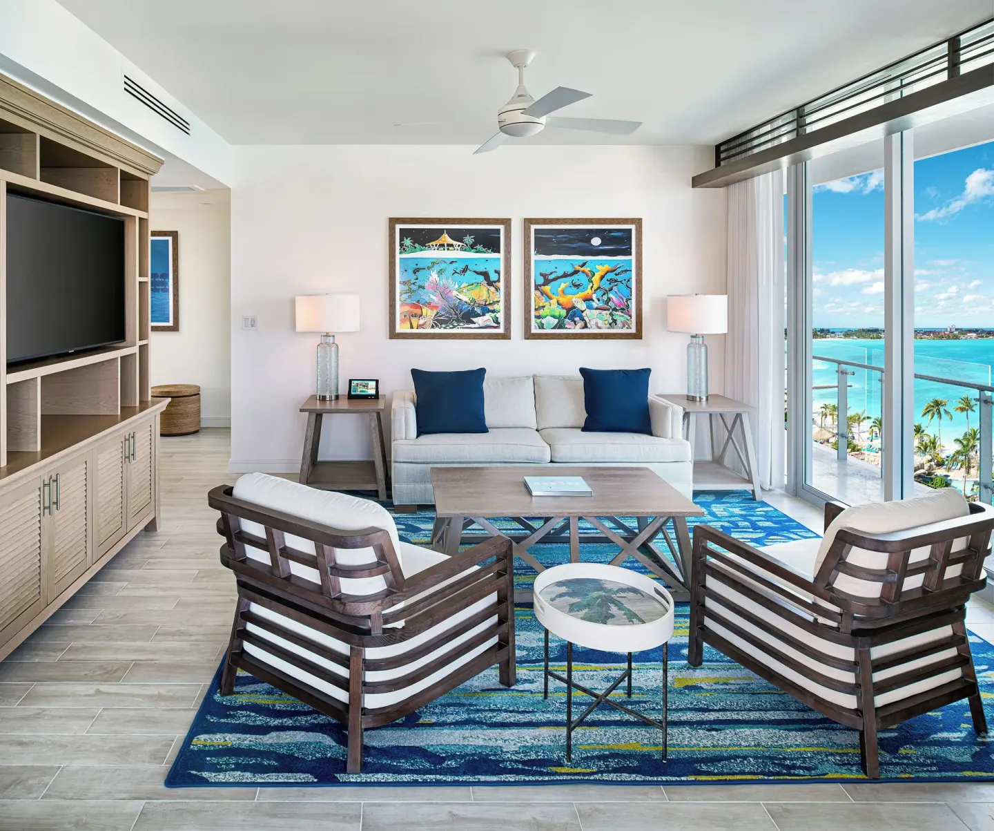 Suite living room with sofa, chairs, and balcony view at Margaritaville Beach Resort - Nassau.