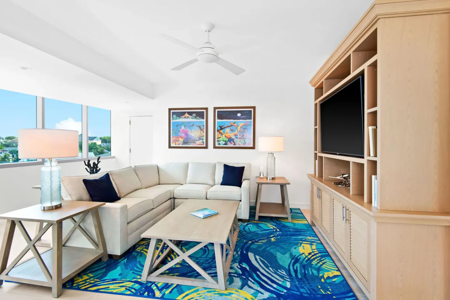 Suite living room with sectional sofa and entertainment cabinet at Margaritaville Beach Resort - Nassau.