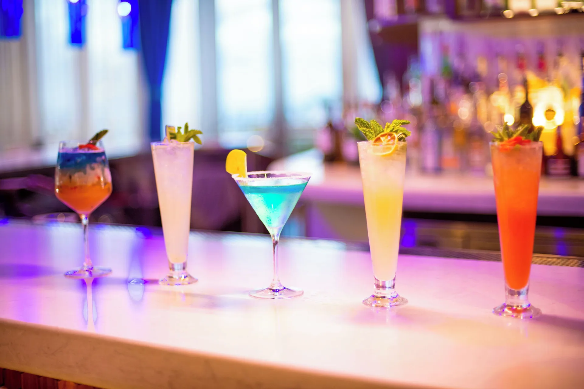 Colorful cocktails lined up on a bar at Margaritaville Beach Resort - Nassau.