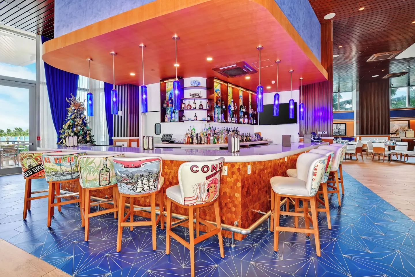 Colorful indoor bar with blue pendant lights at Margaritaville Beach Resort - Nassau.