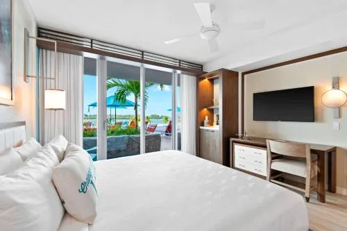 Standard room king bed with TV console and outdoor view at Margaritaville Beach Resort - Nassau.