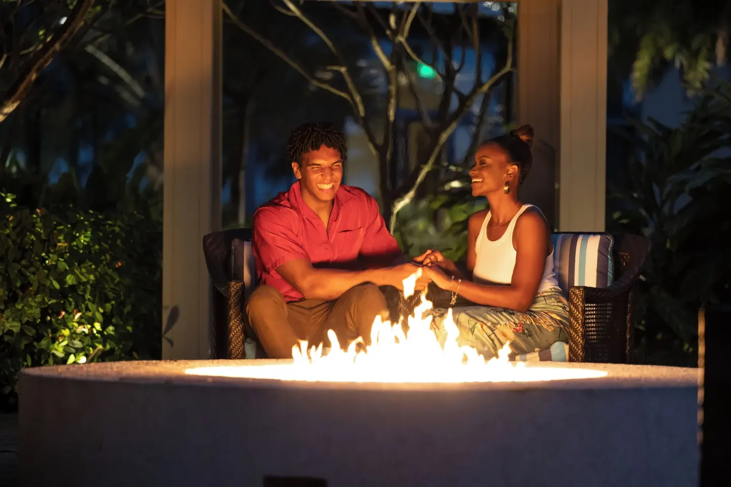 Guests seated by an outdoor fire pit at Margaritaville Beach Resort - Nassau.