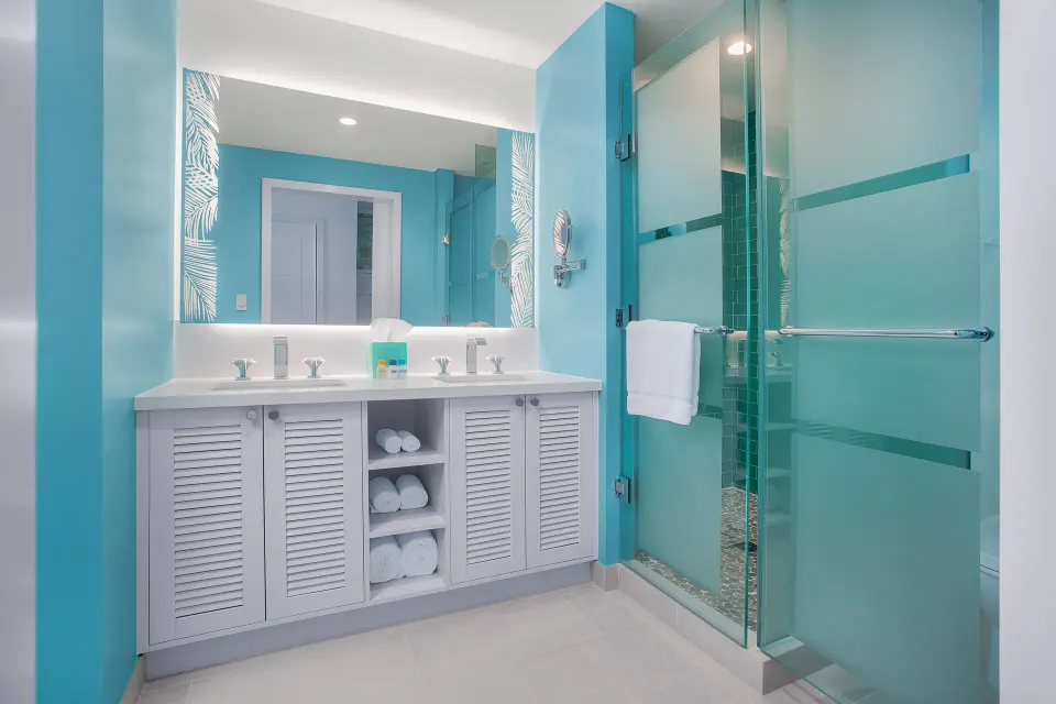 Blue bathroom with double vanity and glass shower at Margaritaville Beach Resort - Nassau.